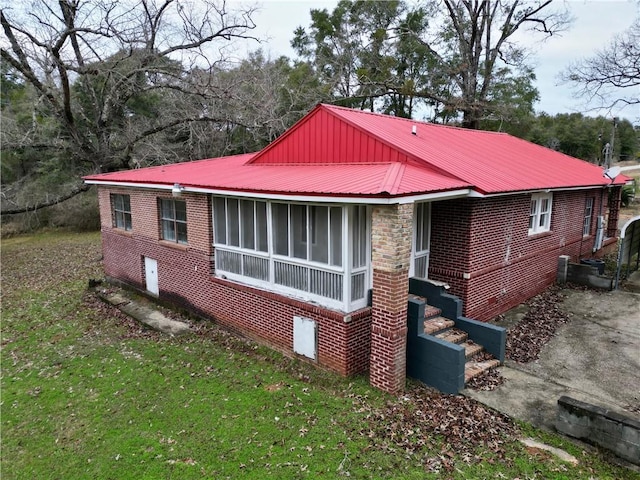 view of property exterior with a sunroom and a lawn