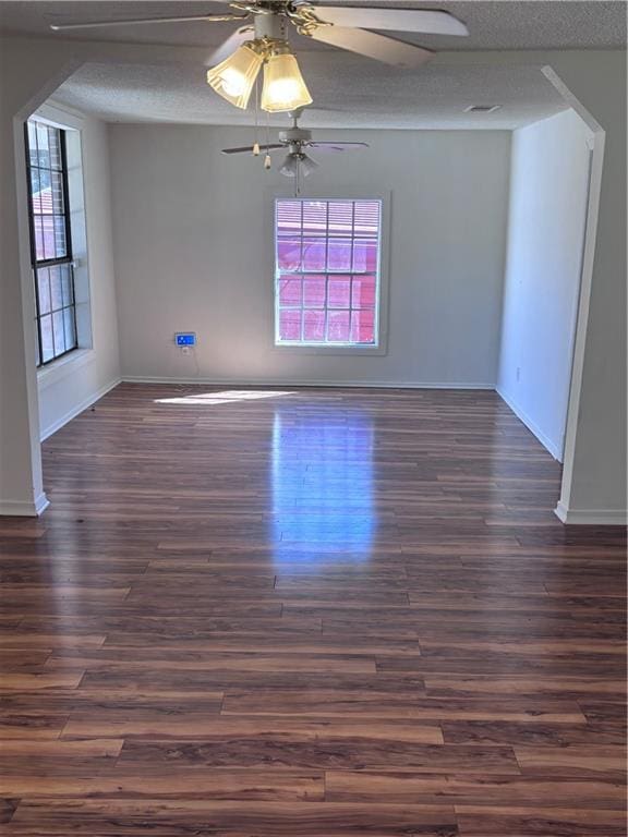 unfurnished room featuring a textured ceiling, ceiling fan, and dark hardwood / wood-style floors