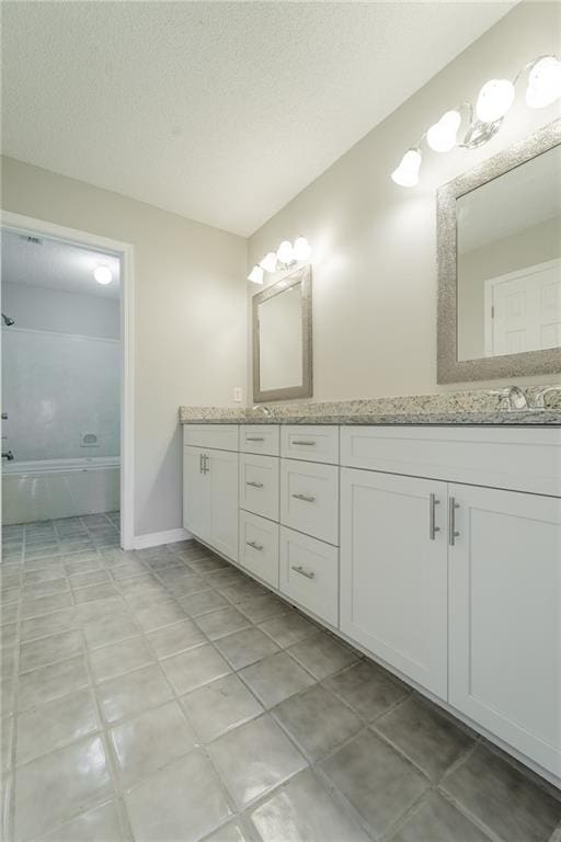 bathroom featuring vanity, a textured ceiling, and tile patterned flooring