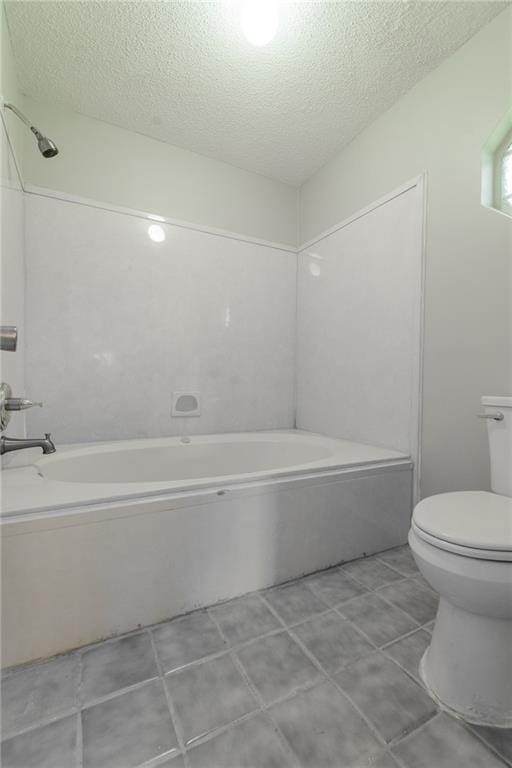 bathroom with toilet, a textured ceiling, and tile patterned flooring