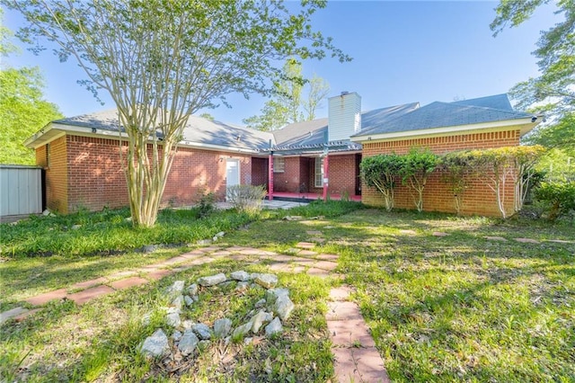 rear view of house with a patio and a yard