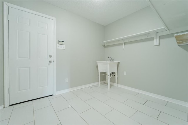 laundry room with a textured ceiling and light tile patterned flooring