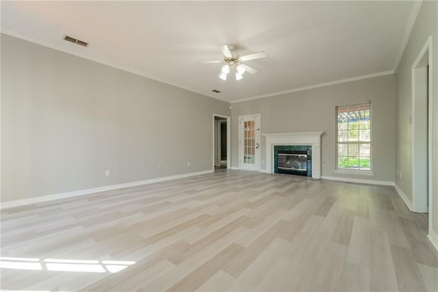 unfurnished living room with light hardwood / wood-style floors, a premium fireplace, ornamental molding, and ceiling fan