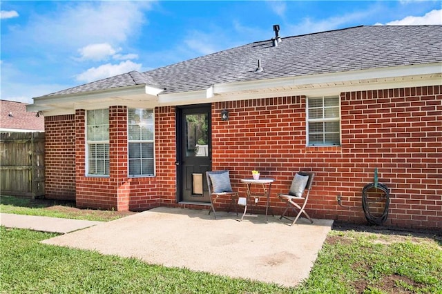 13310 August Dr, Mobile, AL 36695 - back of house featuring a shingled roof, a patio, brick siding, and fence