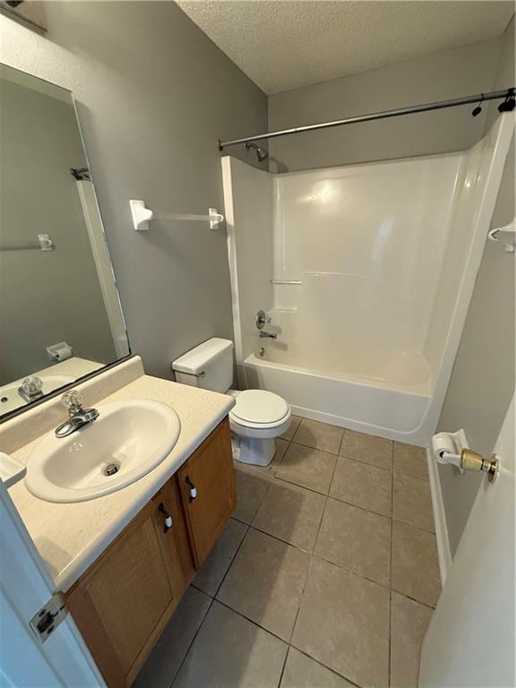 full bathroom with vanity, tub / shower combination, a textured ceiling, tile patterned floors, and toilet