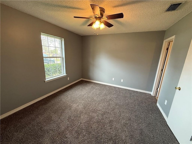 unfurnished room with visible vents, baseboards, a textured ceiling, a ceiling fan, and dark colored carpet