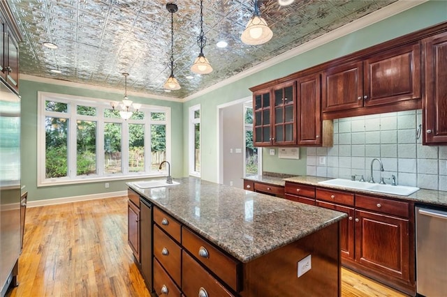 kitchen with crown molding, sink, a center island, light hardwood / wood-style floors, and hanging light fixtures