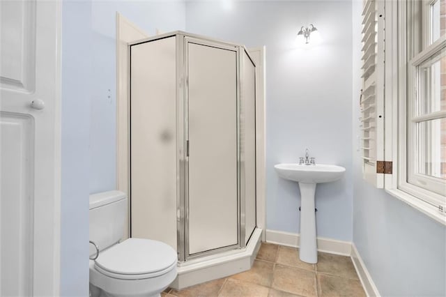 bathroom with tile patterned flooring, toilet, and an enclosed shower