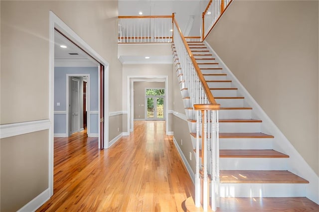 stairs featuring hardwood / wood-style floors and crown molding