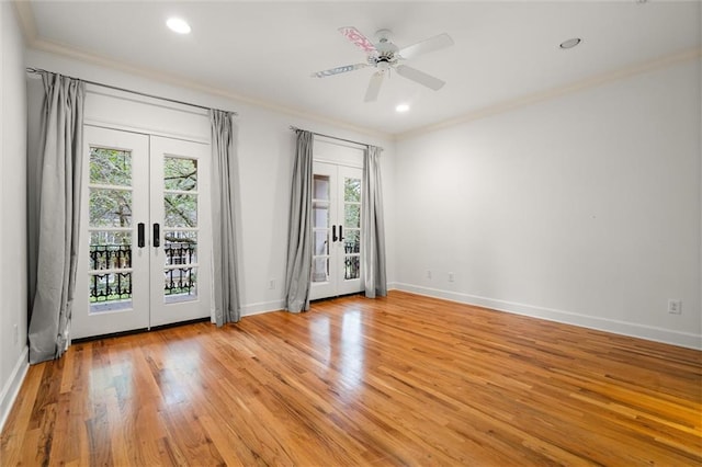 spare room with french doors, light hardwood / wood-style floors, ceiling fan, and crown molding