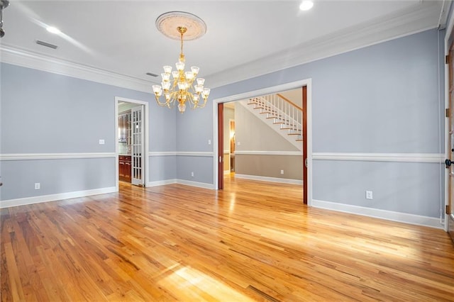 empty room with an inviting chandelier, crown molding, and light hardwood / wood-style flooring