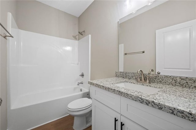 bathroom with wood finished floors, toilet, vanity, and shower / bath combination