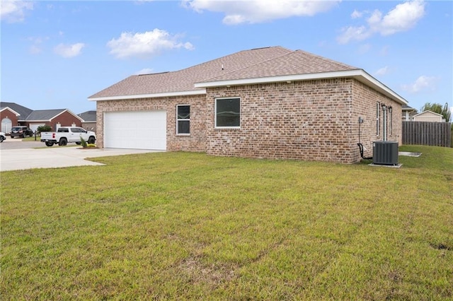 view of side of home featuring brick siding, a garage, concrete driveway, and a yard