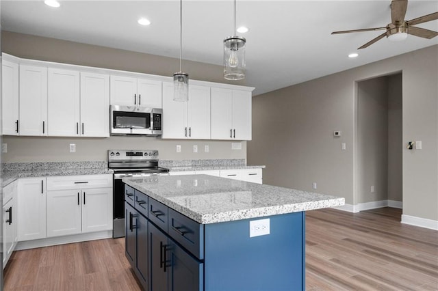 kitchen with light wood finished floors, white cabinetry, ceiling fan, and appliances with stainless steel finishes