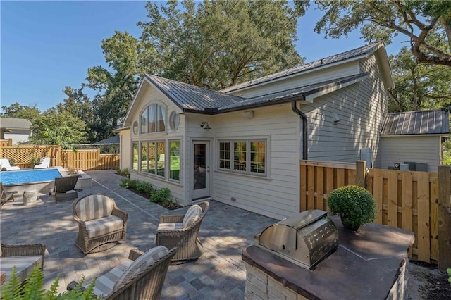 rear view of house with a patio area and an outdoor kitchen