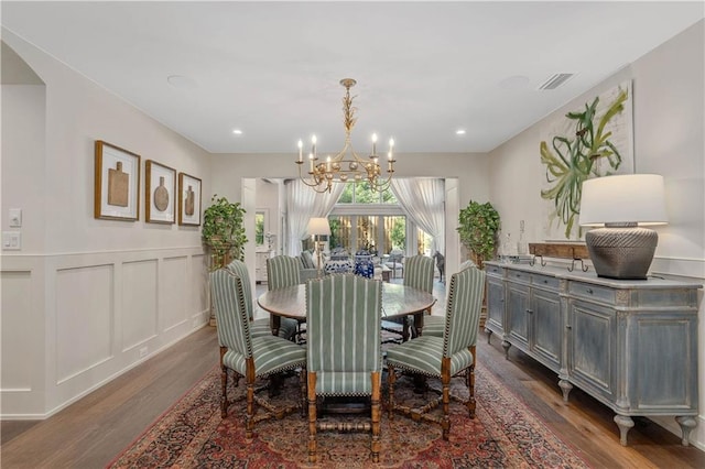 dining space with dark wood-type flooring and a chandelier