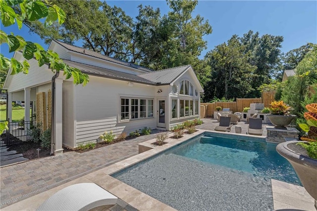 back of property with a patio area and a fenced in pool