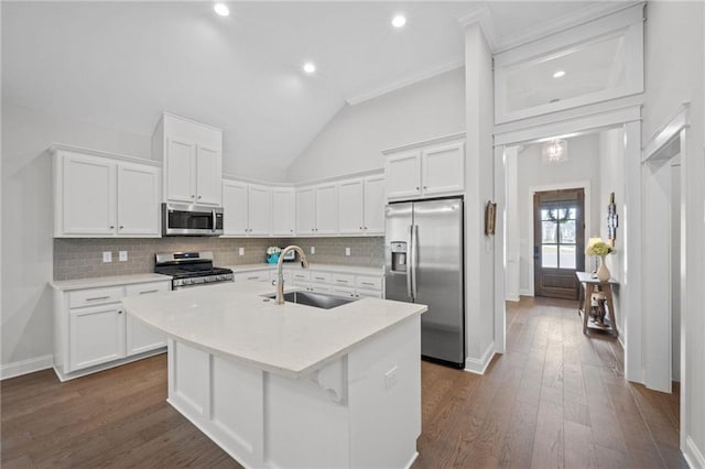 kitchen with a center island with sink, dark wood finished floors, stainless steel appliances, white cabinetry, and a sink