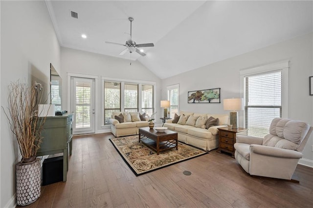 living area featuring high vaulted ceiling, hardwood / wood-style floors, a wealth of natural light, and baseboards