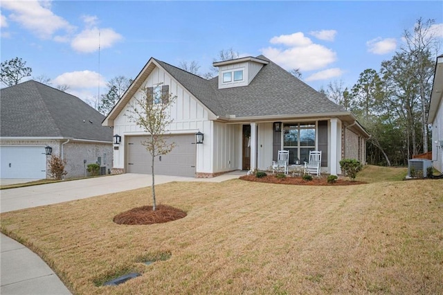 view of front of home with a porch, concrete driveway, board and batten siding, a front yard, and a garage