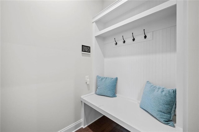 mudroom featuring baseboards and dark wood-type flooring