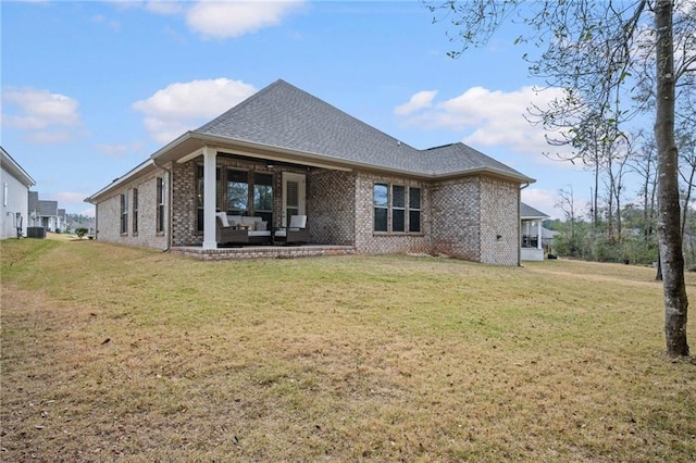 back of house with roof with shingles, a patio, a lawn, and brick siding