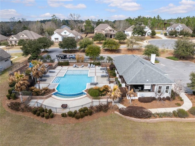 community pool with a residential view, fence, and a patio