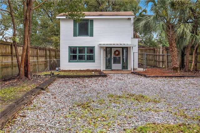 rear view of house featuring a fenced backyard