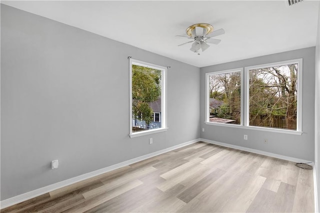 spare room with light wood finished floors, baseboards, and a ceiling fan