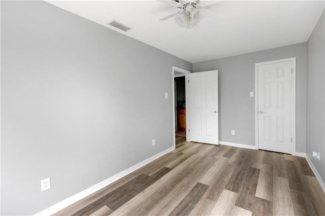 unfurnished bedroom featuring light wood-type flooring, visible vents, ceiling fan, and baseboards