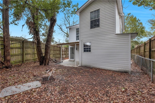 rear view of house with a fenced backyard