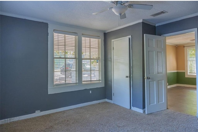 unfurnished bedroom featuring crown molding, carpet floors, and a textured ceiling