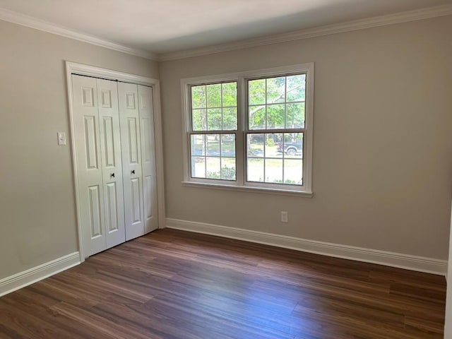 3050 Lacoste Rd, Mobile, AL 36618 - unfurnished bedroom featuring baseboards, dark wood-style flooring, crown molding, and a closet