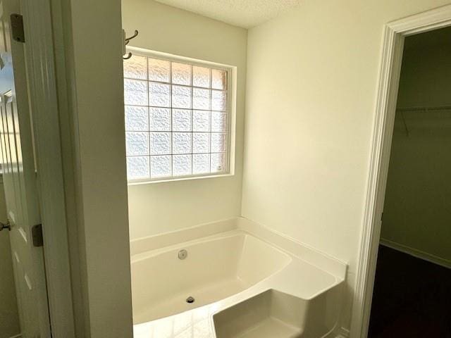 bathroom with a bathtub and a textured ceiling