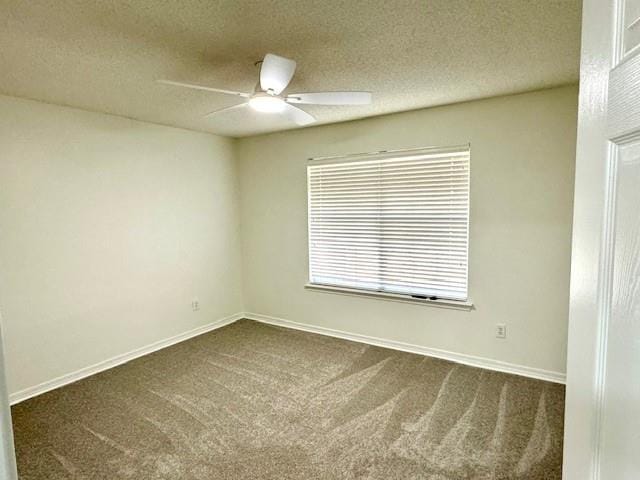 unfurnished room with ceiling fan, dark carpet, and a textured ceiling