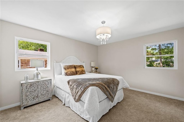 carpeted bedroom featuring an inviting chandelier