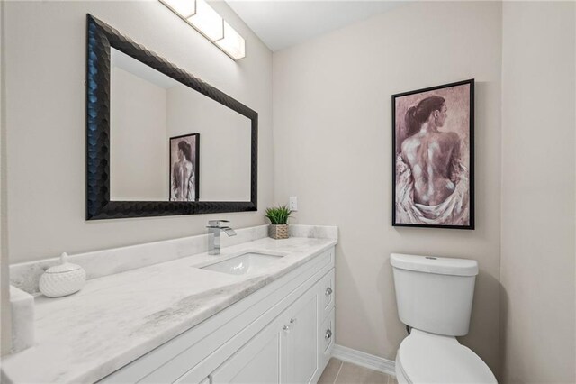 bathroom with toilet, tile patterned floors, and vanity