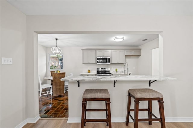 dining room with light hardwood / wood-style flooring, a chandelier, and brick wall