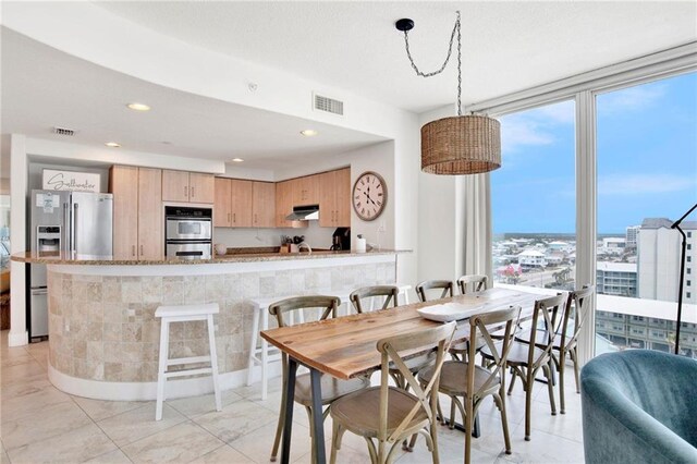 dining room featuring recessed lighting, a wall of windows, and light tile patterned flooring