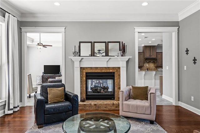 sitting room featuring baseboards, a fireplace, ornamental molding, and dark wood-style flooring