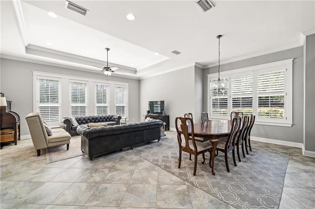 dining space with ornamental molding, plenty of natural light, a raised ceiling, and visible vents