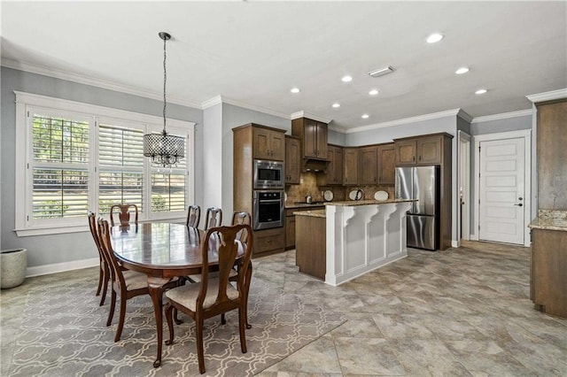 kitchen featuring light stone countertops, stainless steel appliances, ornamental molding, decorative backsplash, and pendant lighting