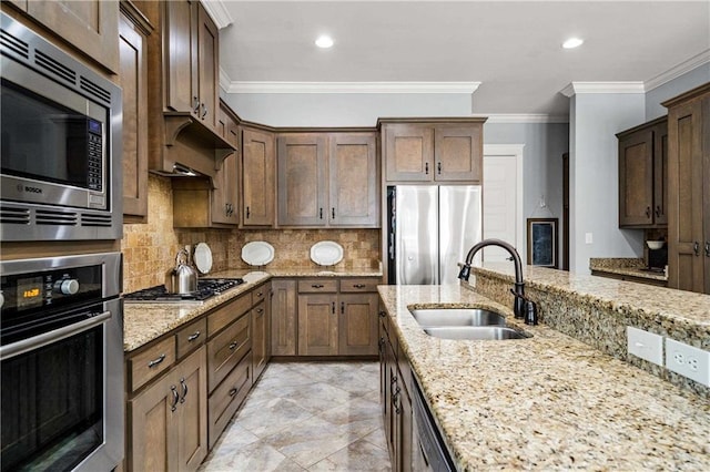 kitchen featuring light stone counters, stainless steel appliances, a sink, tasteful backsplash, and crown molding