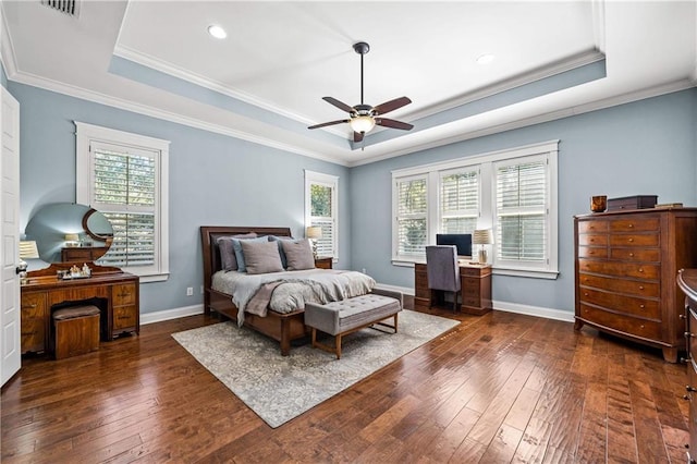 bedroom with dark wood-style floors, a raised ceiling, and baseboards