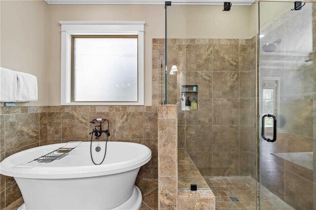 full bathroom with a freestanding tub, tile walls, and a stall shower