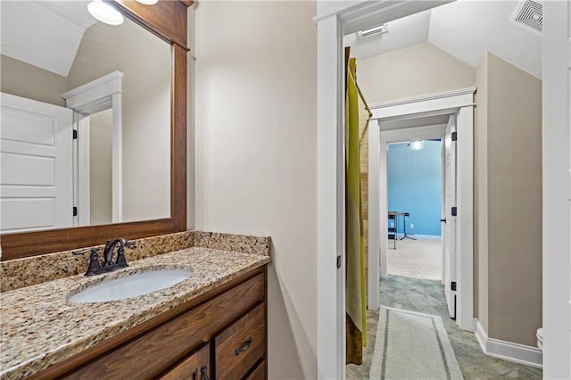 bathroom with baseboards, visible vents, toilet, vaulted ceiling, and vanity