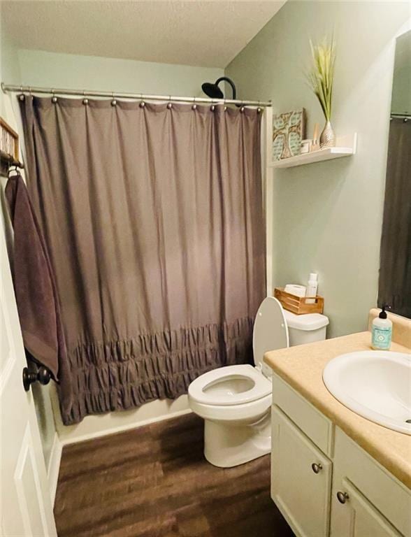 full bathroom featuring toilet, shower / tub combo, hardwood / wood-style floors, and vanity