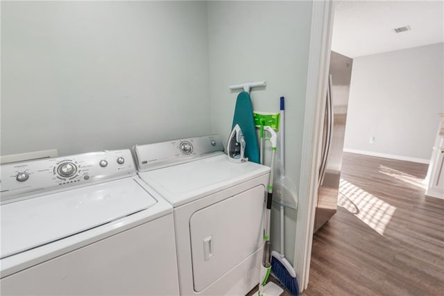 laundry room featuring washer and clothes dryer and hardwood / wood-style flooring