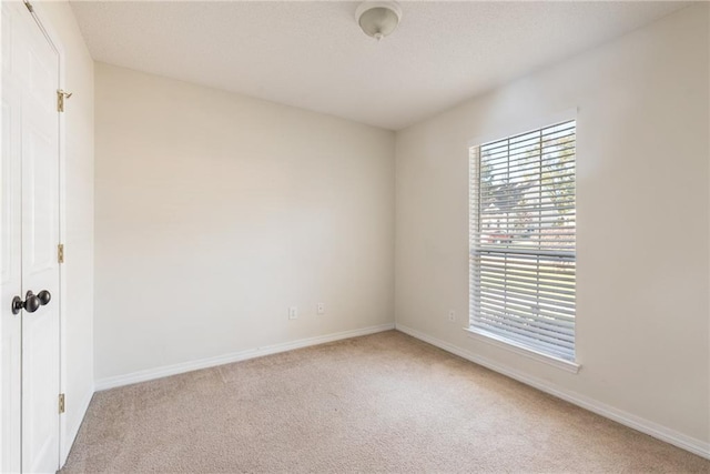 unfurnished room featuring light carpet