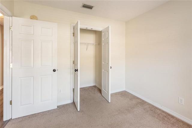 unfurnished bedroom featuring a closet and light carpet